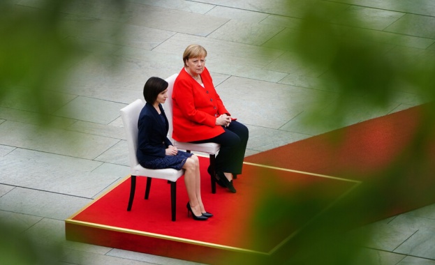 Германският канцлер Ангела Меркел остава седнала при изпълнението на национални