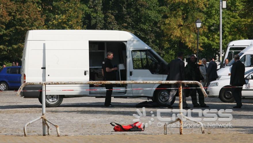 На метри от източния вход на Народното събрание и в близост до една от будките на охраната, стои разтворен червен спортен сак